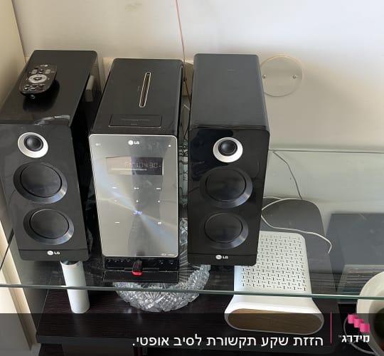 מערכת רמקולים ומודם על מדף זכוכית
